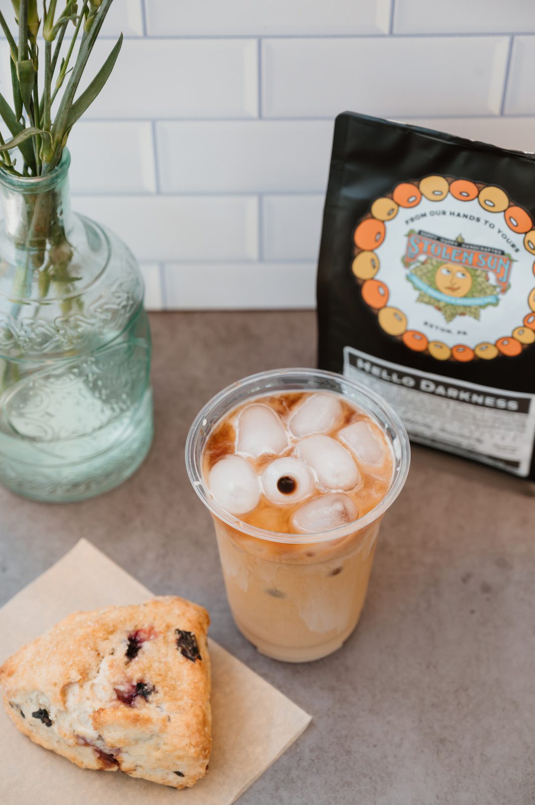 Latte and cookie styled together on a marble counter