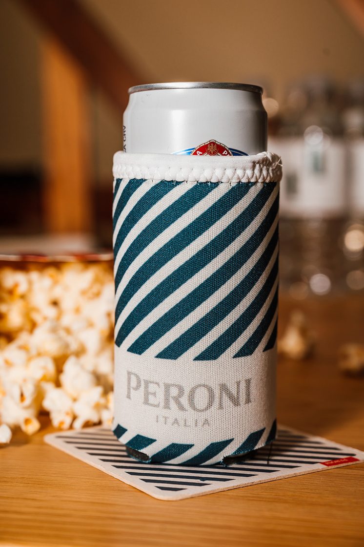Branded canned beverage styled on a striped surface